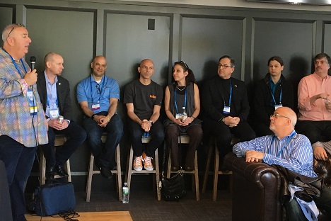 Presenter speaking at conference with a panel of security experts